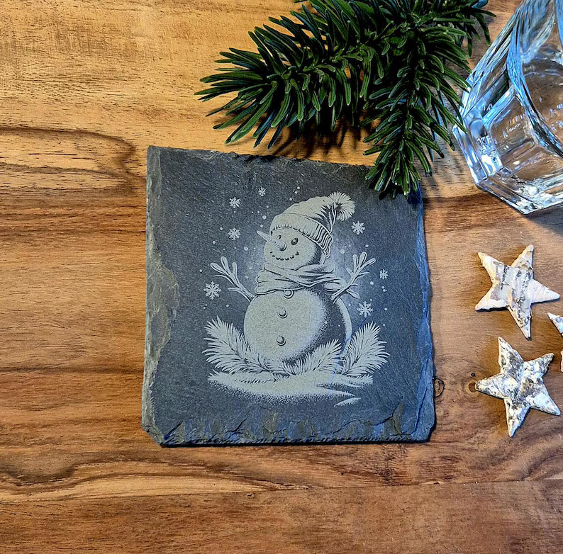 Glasuntersetzer aus Schiefer mit weihnachtlichen Motiven zur Dekoration des Weihnachtstisches